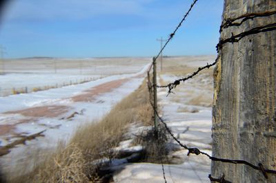 Barbed wire by snow covered street