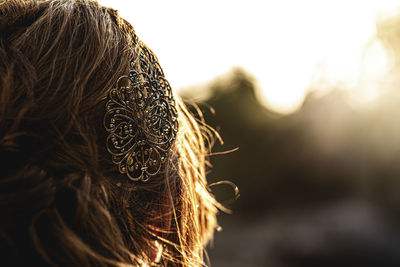 Close-up of woman wearing hair clip during sunset