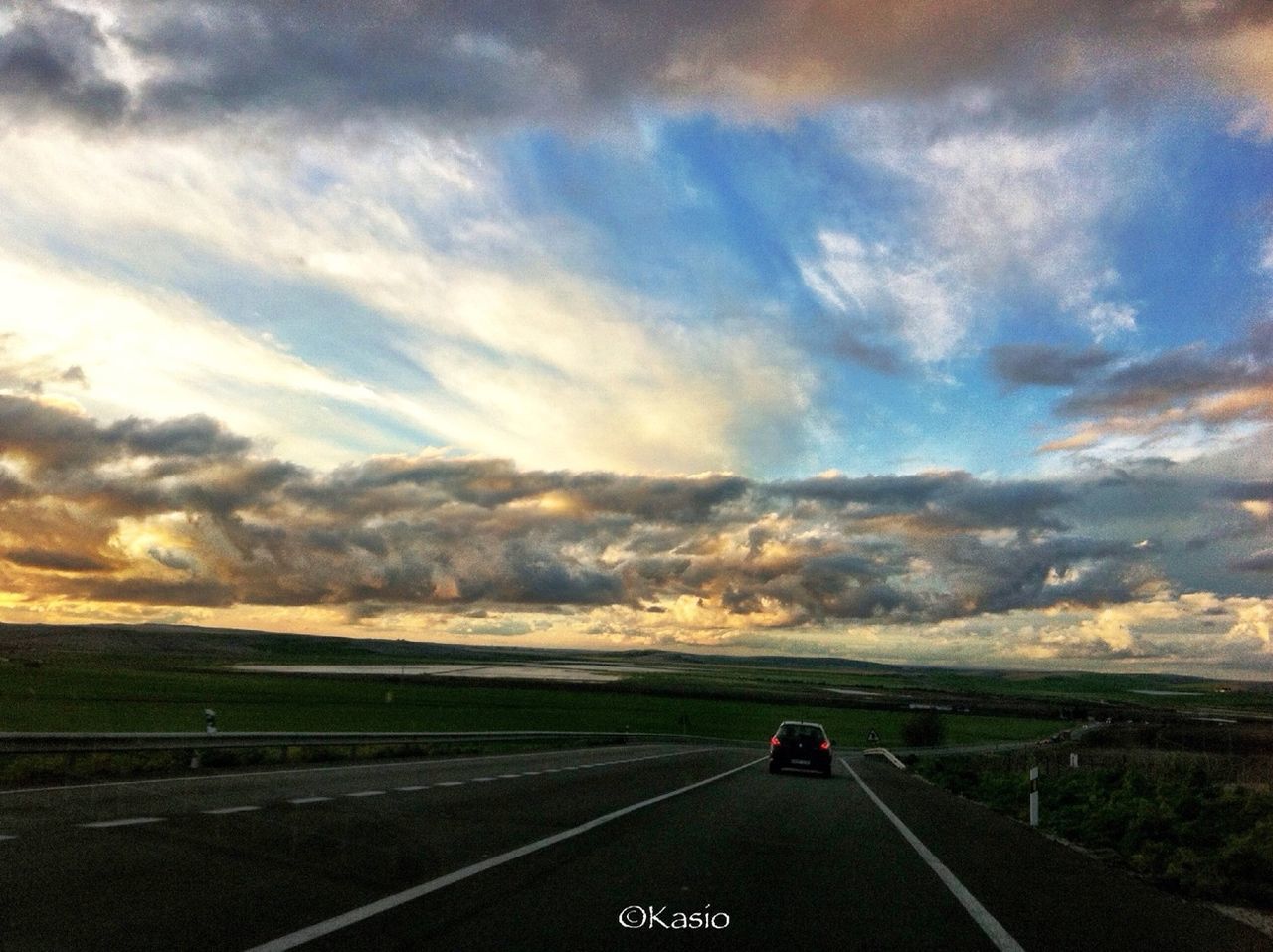 transportation, road, land vehicle, mode of transport, car, sky, road marking, the way forward, on the move, cloud - sky, landscape, country road, highway, travel, sunset, diminishing perspective, cloud, cloudy, vanishing point, windshield