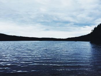 Scenic view of calm lake against cloudy sky