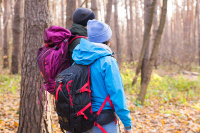 Rear view of people walking in forest