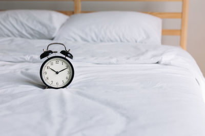 Alarm clock on bed at home