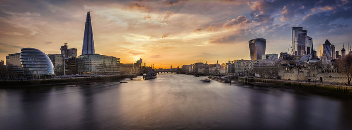 Panoramic view of river and buildings against sky during sunset