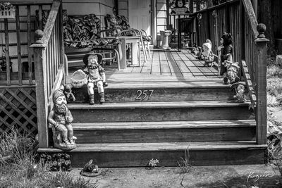 Statue of man sitting on bench against building