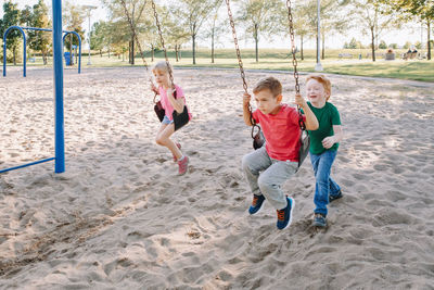 Children playing on swing at park