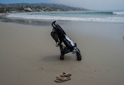 Empty stroller and flip flops at the beach