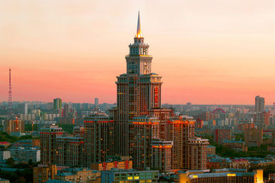 Modern buildings in city against sky during sunset