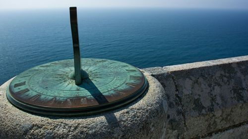 Sundial by retaining wall at seaside