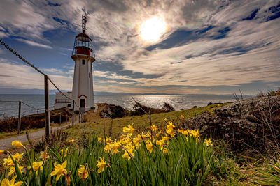 View of lighthouse by sea against sky