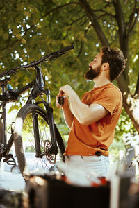 Side view of young woman with bicycle