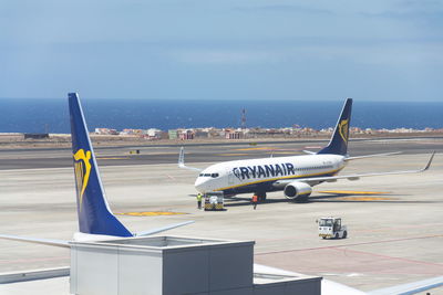 Airplane on airport runway against sky