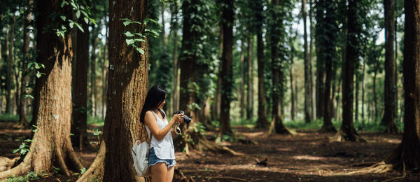 Young woman using mobile phone in forest