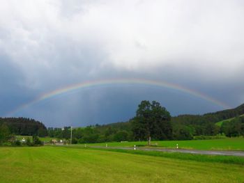 Scenic view of rainbow over land against sky