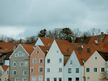 Houses and buildings in town against sky