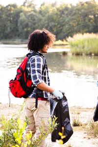 Rear view of man standing by lake