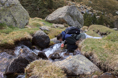 Rear view of man standing by stream