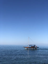 Sailboat sailing on sea against clear sky