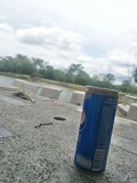 Close-up of drink on table at beach against sky