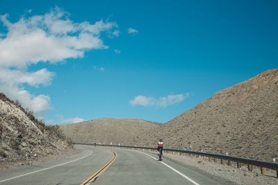 Rear view of person cycling on road