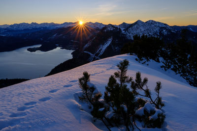 Scenic view of snow covered mountains against sky at sunset