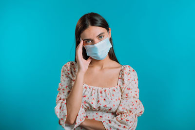 Portrait of beautiful young woman over blue background