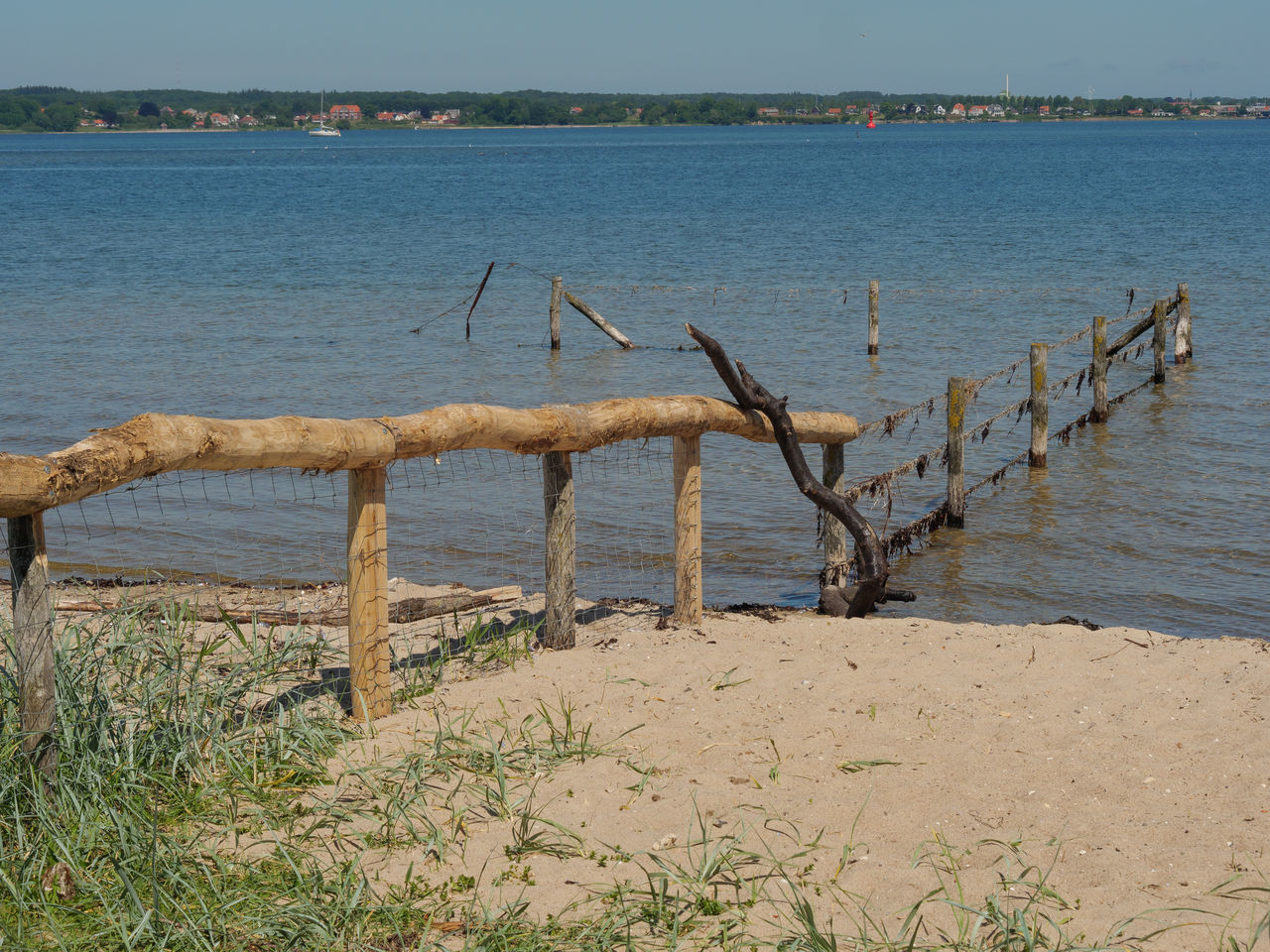 WOODEN POSTS ON BEACH