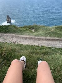 Low section of woman legs by sea