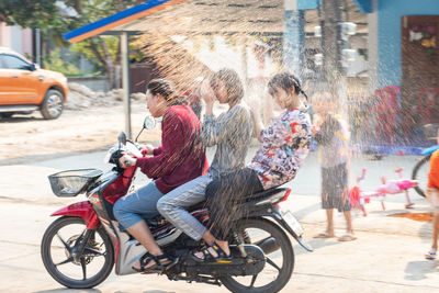 People riding motorcycle on street in city