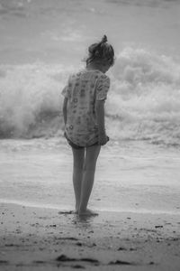 Rear view of woman walking on beach