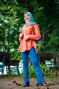 Portrait of smiling man standing against trees