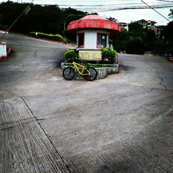 Bicycle parked on road by building