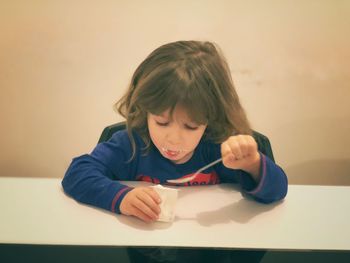 Cute girl eating ice cream at table