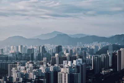 View of cityscape against cloudy sky
