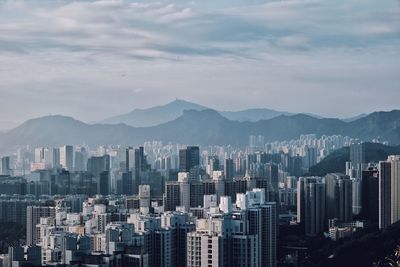 View of cityscape against cloudy sky