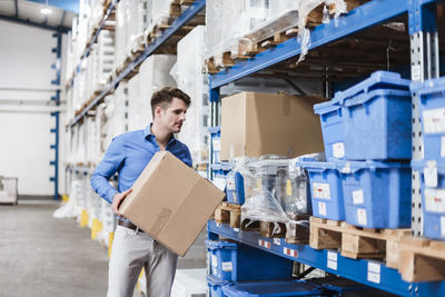 Man working in warehouse holding box