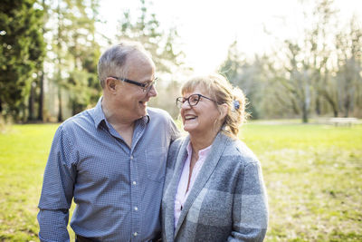 Elderly couple laughing and smiling together outdoors.