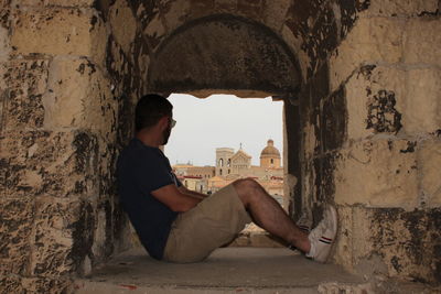 Side view of man sitting at home