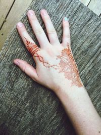 Close-up of human hand touching wood