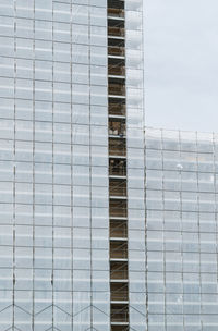 Low angle view of modern glass building against sky