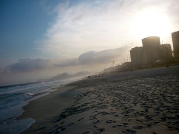 View of calm beach against sky during sunset