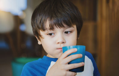 Close-up portrait of boy drinking coffee