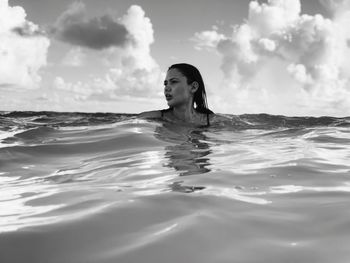 Woman looking away while swimming in sea