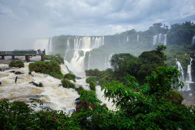 Scenic view of waterfall against sky