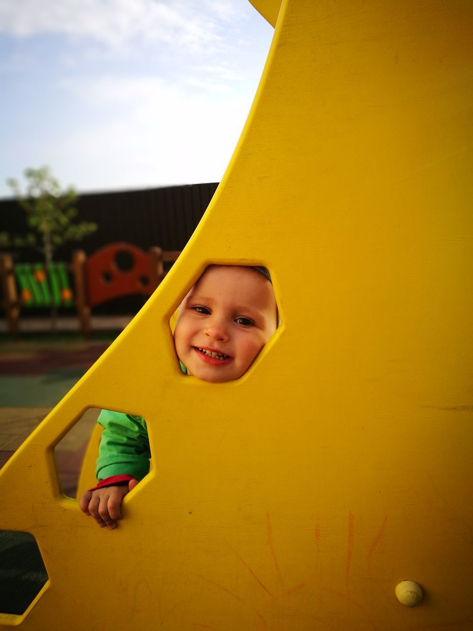 childhood, boys, playground, one person, elementary age, innocence, yellow, playing, portrait, smiling, looking at camera, happiness, fun, real people, leisure activity, outdoor play equipment, one boy only, day, child, cheerful, outdoors, children only, close-up, people