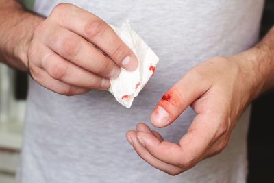 Midsection of man holding ice cream on table