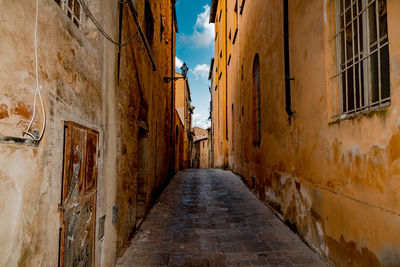 Alley amidst buildings against sky