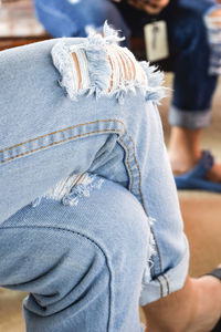 Midsection of person wearing torn jeans