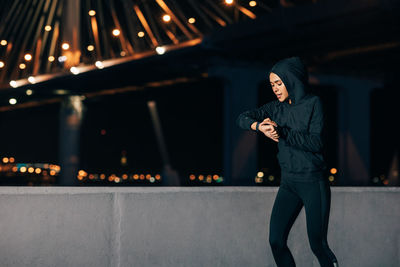 Woman looking at illuminated camera at night