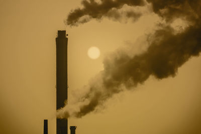 Smoke emitting from chimney against sky