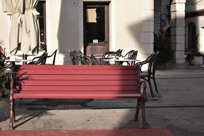 Empty chairs and table against building